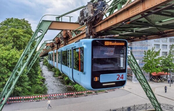 Un teleférico azul con el número 24 cruzando un puente sobre un río.