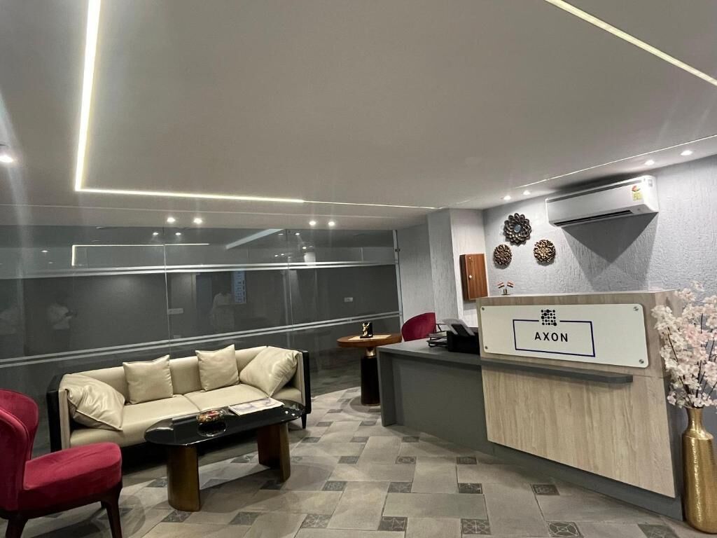 Una moderna hall d'hotel con una reception, un divano e un tavolino.
