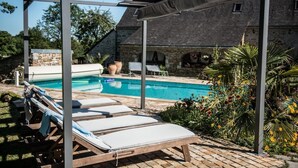 A pool area with lounge chairs and a pergola. - Gite de la Bouysse Haute (CUZANCE)