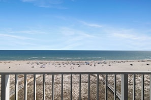 Ein Strand mit blauem Himmel, sandigem Ufer und Blick auf den Ozean.