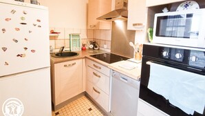 Una cocina compacta equipada con refrigerador, estufa, microondas y lavavajillas.