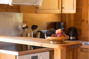Enjoy cooking in this kitchen with a stove, kettle, and utensils, surrounded by a woven basket and natural materials.