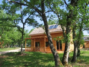 Escape to a serene retreat surrounded by lush greenery and trees, with a cozy porch and easy access to the cabin.