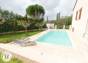 Relax by the pool surrounded by a lush garden and comfortable lounge chairs.