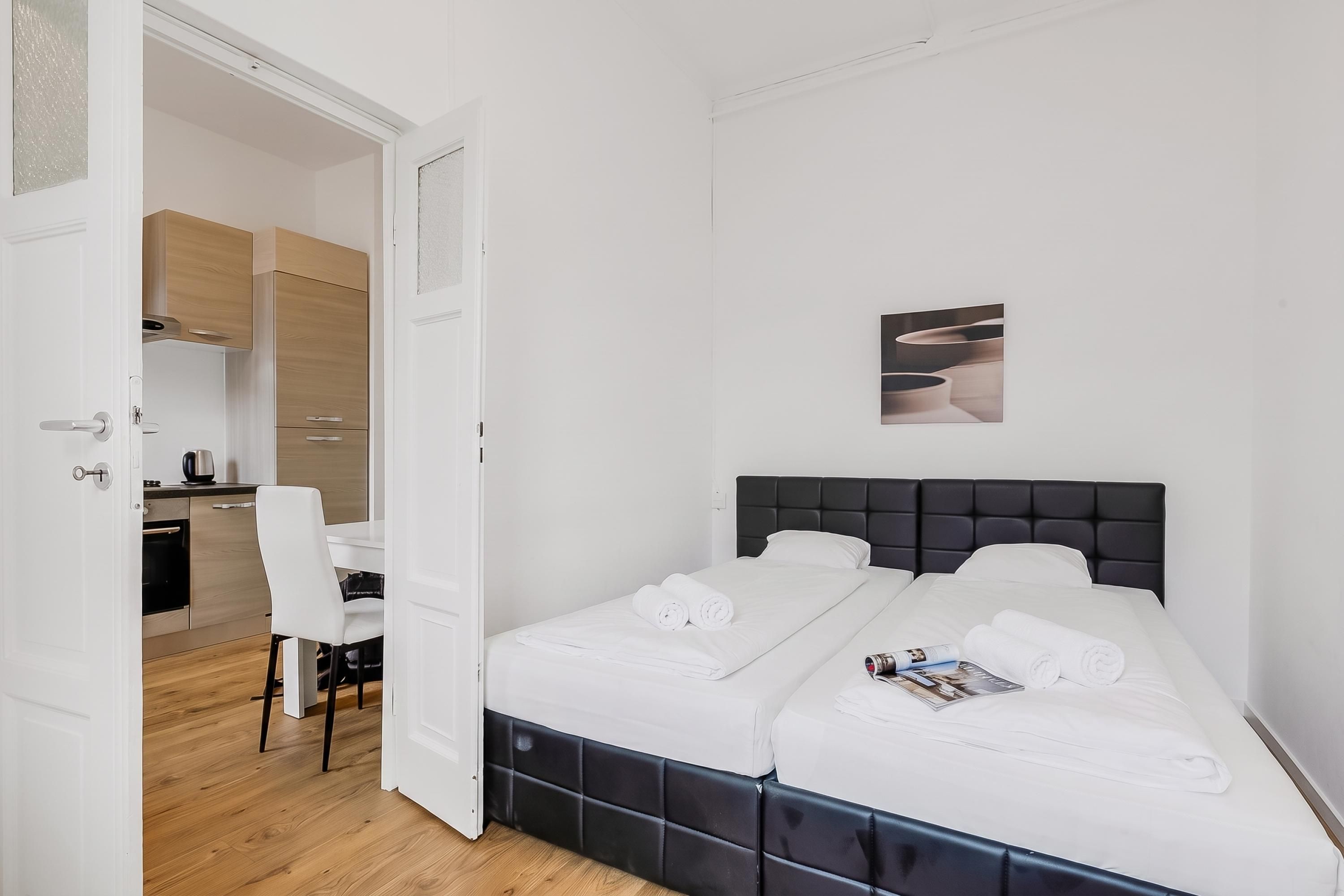 A hotel room with a bed, a desk, and a chair.