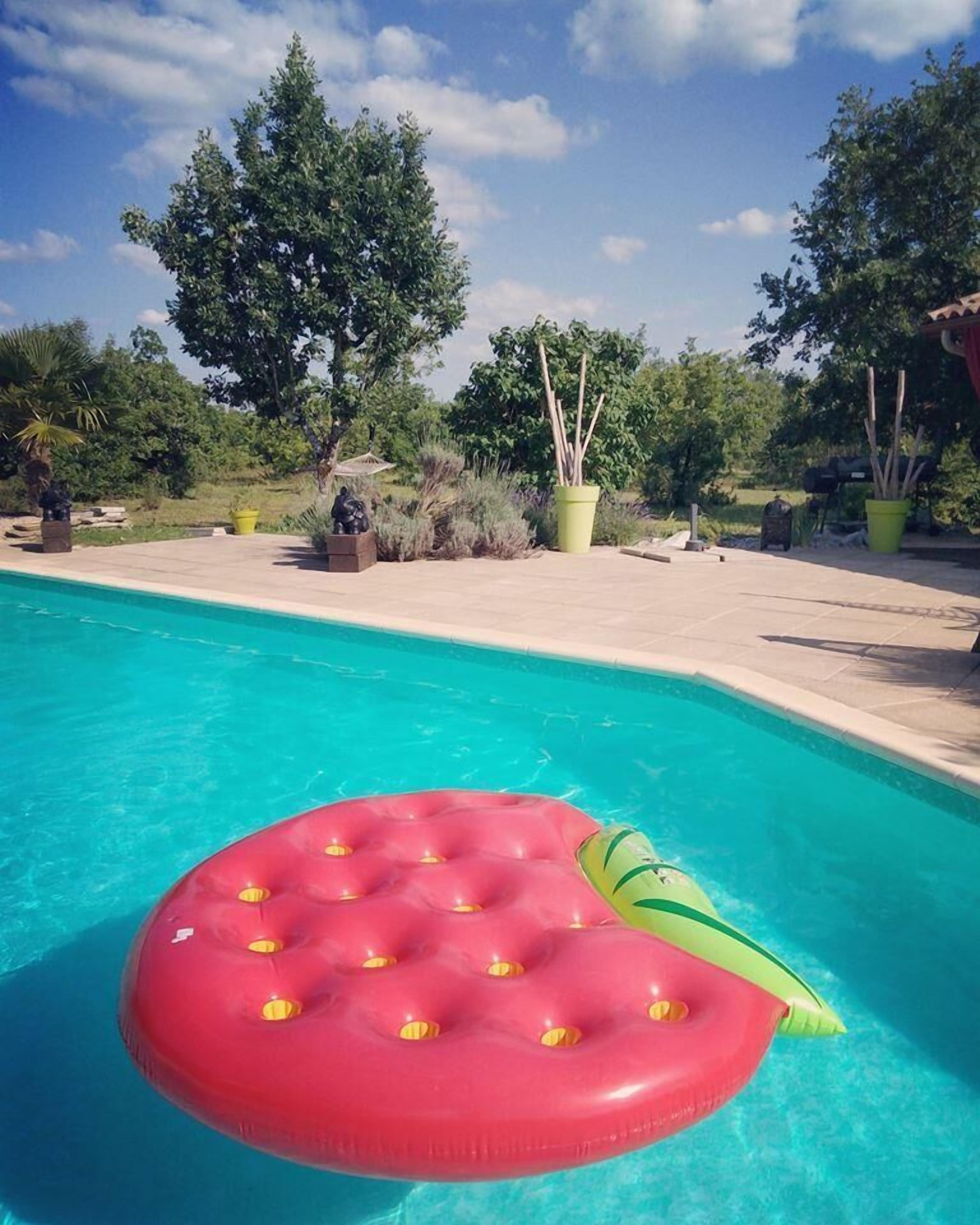 A swimming pool with a red inflatable float.