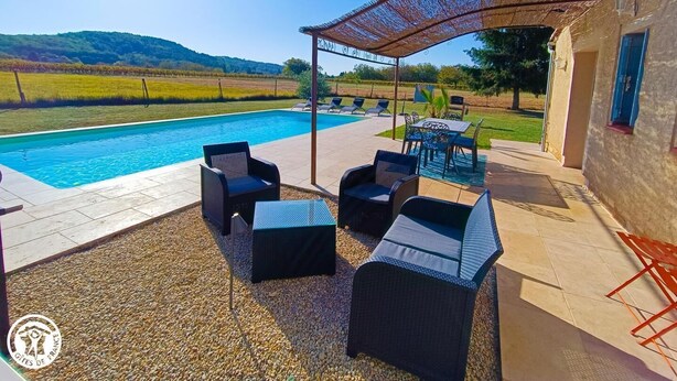 Ein Poolbereich mit Pergola, Sitzgelegenheiten und Blick auf die Landschaft.