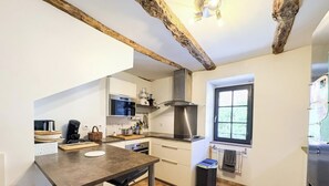 Una cocina con techo de madera, ventana y horno empotrado.