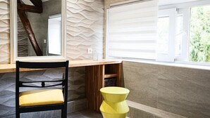 A modern room with a wooden desk, a chair, and a unique yellow stool. - Gîtes de France® - Villa le Simonet (BETAILLE)