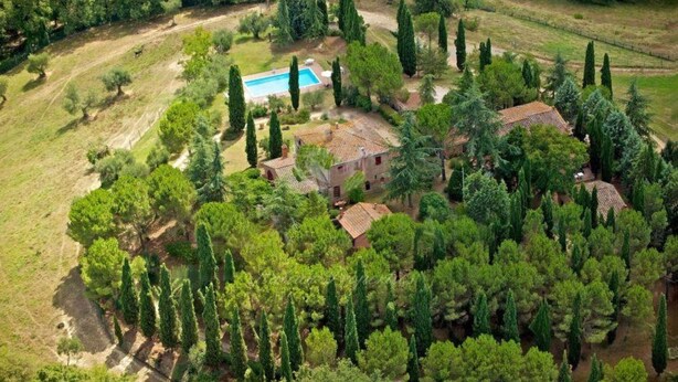 An aerial view of a property with multiple buildings surrounded by dense greenery and a swimming pool. - Borgo Melograno - SOL Apartment (Toscana)