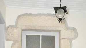 A white door with a frosted glass panel, set in a stone wall with a small step leading up to it. - Gîtes de France® - Chez Mamie (LACAVE)