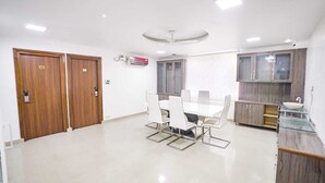 A modern kitchen with a white countertop, a sink, and wooden cabinets. - Sunrise A Boutique Hotel (Hyderabad)