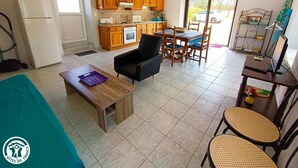 A compact kitchen with wooden cabinets and a dining area with a table and chairs.