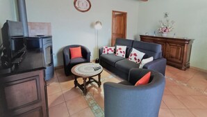 Ein Wohnzimmer mit einer Couch, einem Sessel, einem Couchtisch und einem Kamin.