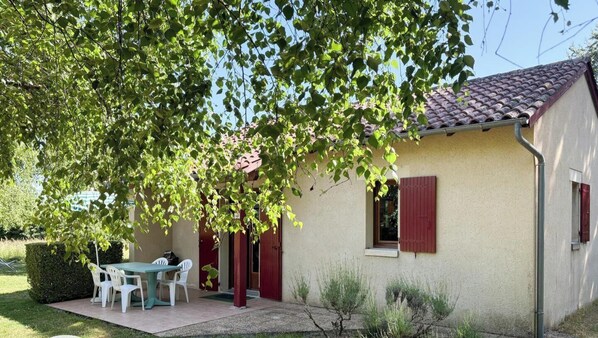 A house with a patio, a table, and chairs.