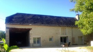 A single-story building with a sloped roof, a garage door, and a small porch area.