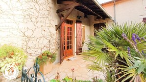 Un edificio rústico con fachada de piedra, puerta de madera y un porche cubierto.