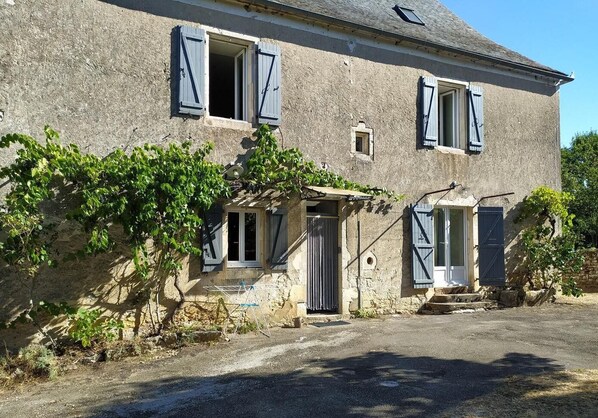 A two-story stone house with a gravel driveway and a small garden area. - Chez Pierrot Vacation Rental - MAYRAC (MAYRAC)