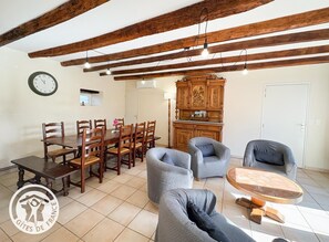 Un comedor con una mesa y sillas de madera, un reloj en la pared y un aparador con tallas elaboradas.