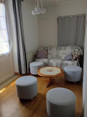 A cozy living room with a sofa, ottomans, and a coffee table.