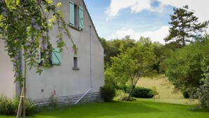 A house with a sloped roof, a small window, and a stone foundation.