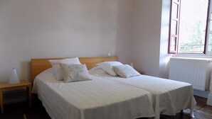 A double bed with white linens, a wooden headboard, and two bedside tables with lamps. - Gîtes de France® - The Presbytery (SENAILLAC-LATRONQUIERE)