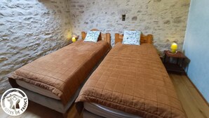 A rustic room with two beds, stone walls, and a small window. - 46g11622 - Lherm - Gîte (LHERM)