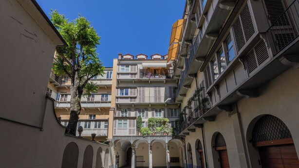 Un estrecho callejón entre edificios con balcones y arcos.
