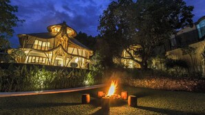 A modern building with a unique architectural design, featuring a circular structure and a fire pit in the foreground. - Ahura Luxury Villas (Pecatu)