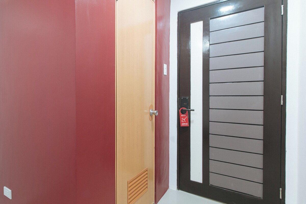 A red door with a wooden panel and a black-framed window.