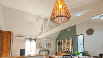 Une cuisine moderne dotée d’un îlot central, de meubles en bois et d’un luminaire suspendu.
