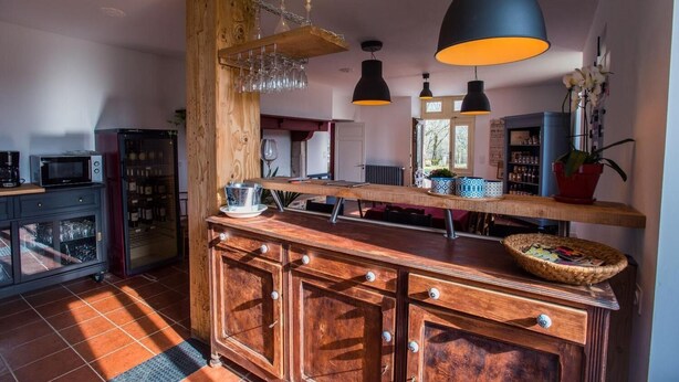 Una cocina con armarios de madera, un enfriador de vinos empotrado e iluminación colgante.