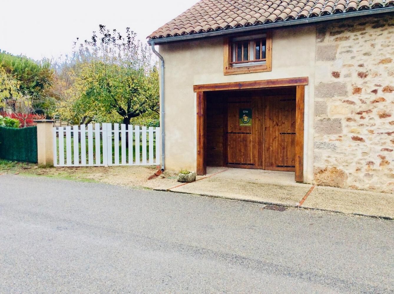 Un bâtiment en pierre avec une porte en bois et une petite fenêtre.