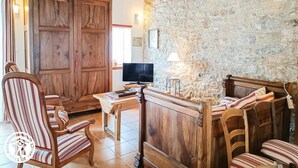 Ein rustikales Interieur mit Holzmöbeln, einer Steinwand und einem Fernseher.
