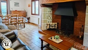 Un salon chaleureux avec une cheminée, des meubles en bois et un coin repas.