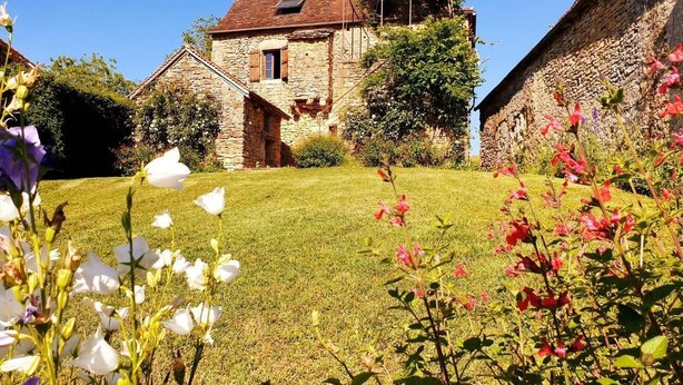 A stone house with a sloped roof and a small window.