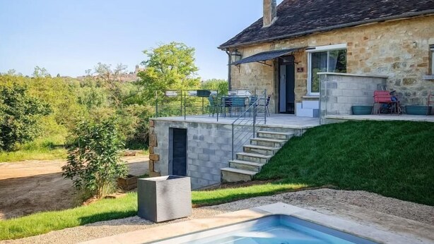 Una casa de piedra con piscina, un porche cubierto y una escalera que lleva a una terraza.