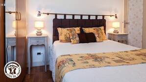 A bedroom with a bed, two bedside tables, and a nightstand. - Gîtes de France® - La Cigale (SAINT PROJET)