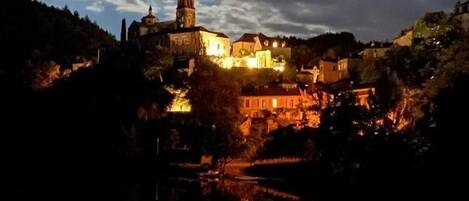 Eine historische Stadt mit markanter Kirche und Turm, umgeben von Hügeln und spiegelnd in stillen Gewässern.