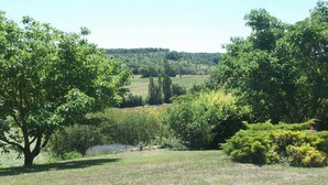 A natural landscape with trees, a small body of water, and a hilly background. - Gîte de Sisamé - Pern (PERN)