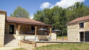 A stone building with a covered patio, outdoor seating, and a grill area. - Domaine de Ratier - LES Arques (LES ARQUES)