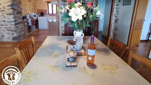 Una mesa de comedor con mantel floreado, una botella de licor y un adorno decorativo.