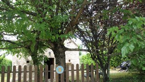 A rustic stone building with a wooden fence and a sign indicating a restaurant. - Gîtes de France® - Le Fournil (SOULOMES)