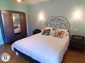 Un dormitorio con cama, armario y dos mesitas de noche.
