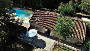 En villa med swimmingpool, terrasse med udend ørs møbler og tagtækket med fliser.