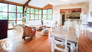 Amplia sala de estar con un ventanal grande, una mesa de comedor y zona de cocina.