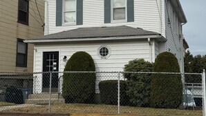 A two-story house with a gabled roof, a front door, and a small porch. - Cozy Studio with reading nook (White Plains)