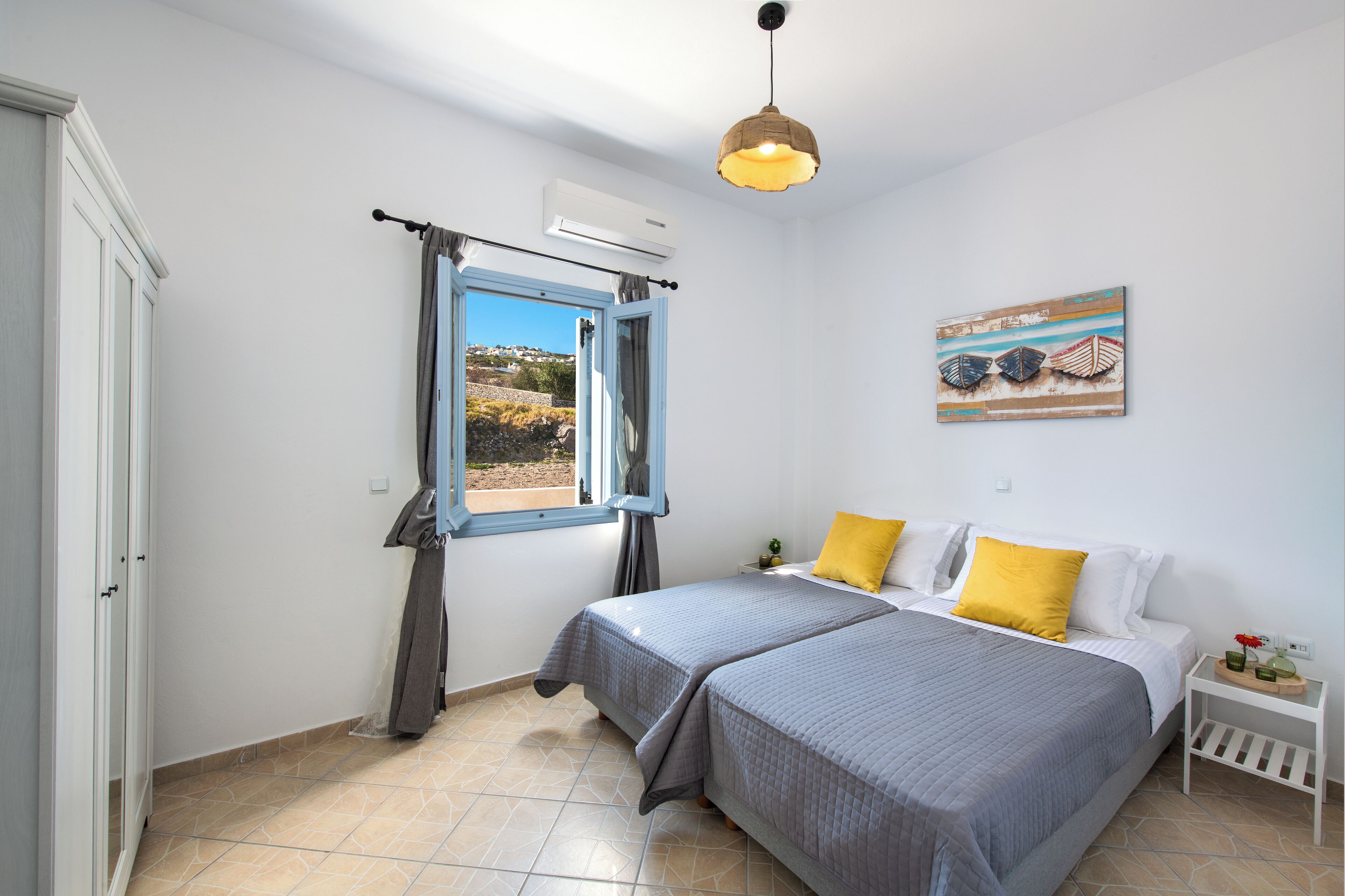 A bedroom with two beds, a window with curtains, a ceiling light, and a wall-mounted air conditioner.