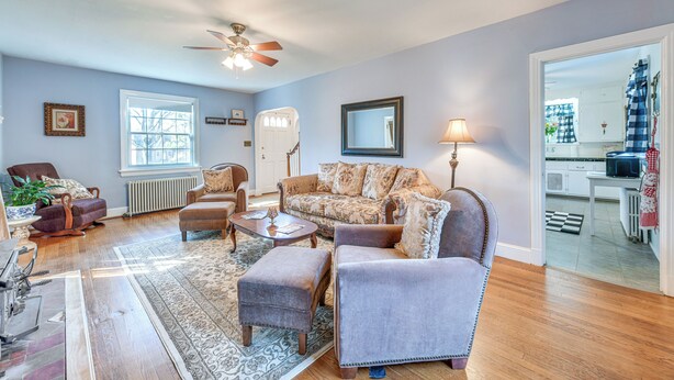 Een woonkamer met een bank, fauteuils, een salontafel en een vloerkleed.