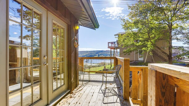 A wooden deck with a view of a lake and mountains, a covered patio with chairs, and a wooden fence. - Breathtaking Lake Views Walk to Alpine Lake (Terra Alta)